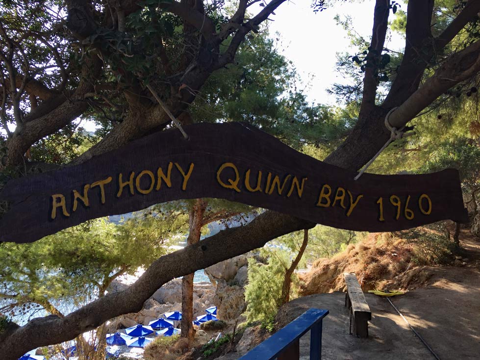 schild-Anthony-Quinn-Bay-haengt-an-einem-baum-weiter-unten-blaue-liegen-am-strand-auf-Rhodos-strand-schnorcheln-mit-kind