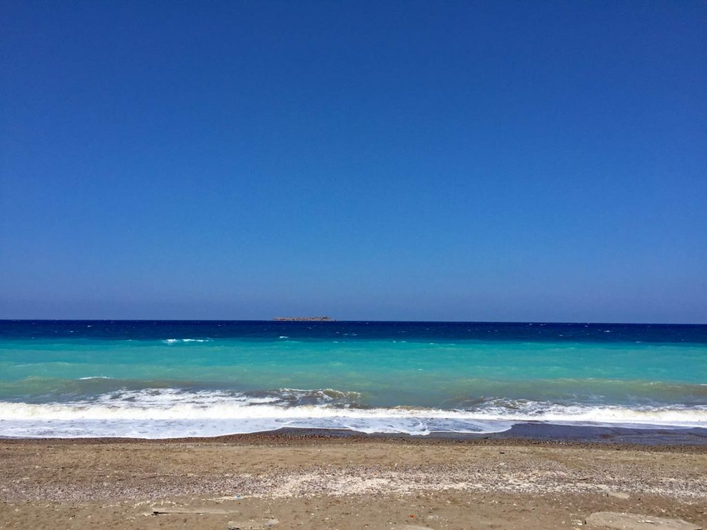 strand-mit-weiss-aufschaeumenden-wellen-und-meer-in-verschieden-blau-farbenden-toenen-auf-rhodos