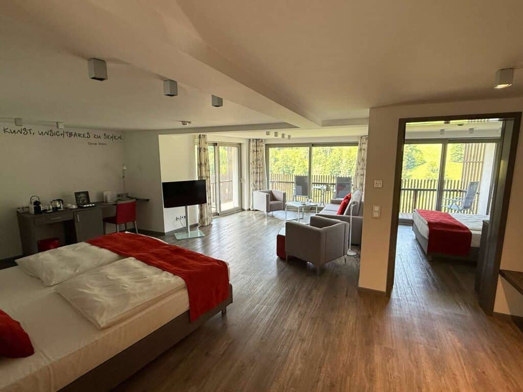 Familienurlaub im Schwarzwald: Unsere Erfahrungen im Hotel Traube Tonbach in Baiersbronn familienzimmer-im-kohlwald-der-traube-tonbach-grosser-wohnbereich-mit-bett-und-coach-extra-schlafzimmer-und-großem-balkon
