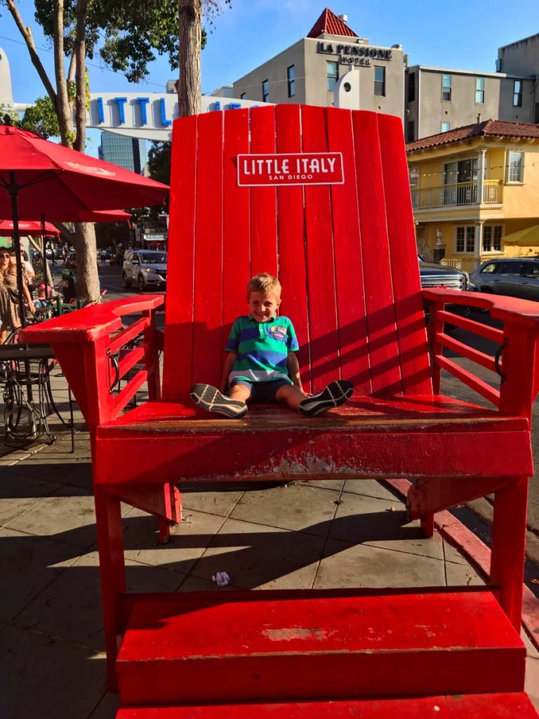 kind-auf-uebergrossem-roten-stuhl-in-little-italy-san-diego-kalifornien