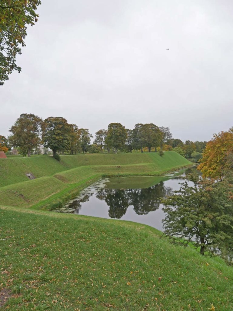 17 Tipps für Kopenhagen mit Kindern - Sehenswürdigkeiten, toller Spielplatz und das beste Museum für Familien eckige-kanaele-an-gruenen-wiesen-mit-baeumen-im-kastell-kopenhagen