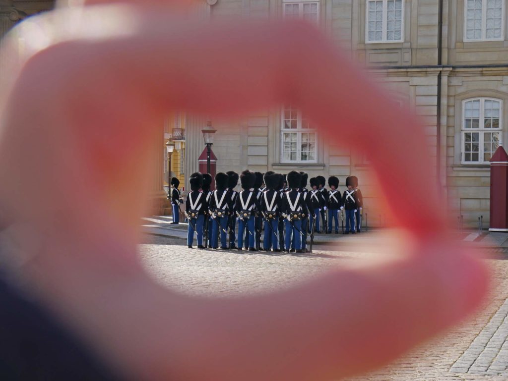 17 Tipps für Kopenhagen mit Kindern - Sehenswürdigkeiten, toller Spielplatz und das beste Museum für Familien wachabloesung-amalienborg-soldaten-in-reihen-fotografiert-durch-kinderhand
