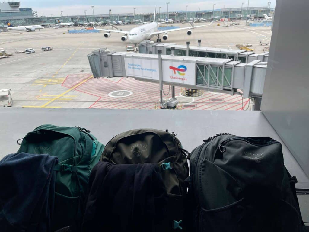 rucksaecke am flughafen mit blick auf flugzeug vor weltreise