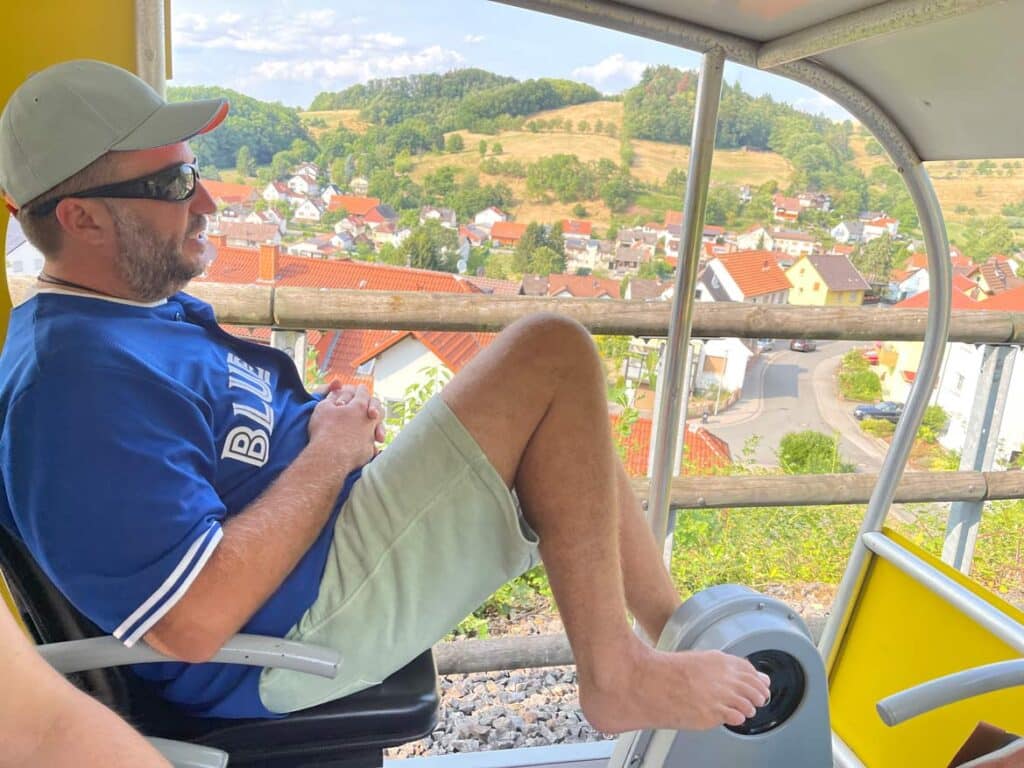 Odenwald mit Kindern mann-faehrt-in-solar-draisine-im-odenwald-mit-blick-auf-dorf