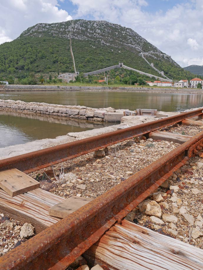 Kroatien Route - der ultimative Kroatien Familienurlaub blick-ueber-schienen-und-saline-auf-lange-mauer-im-berg-ston-kroatien