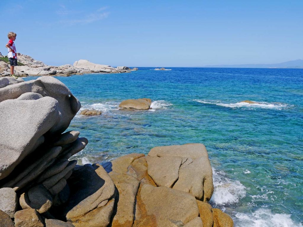 Sardinien mit Kindern - 9+ Highlights für den Familienurlaub kind-auf-felsen-am-meer-strand-capo-testa-sardinien-sehenswuerdigkeiten