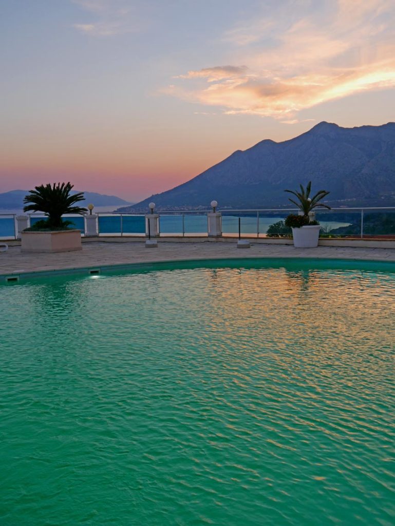 pool-mit-aussicht-auf-berge-und-meer-im-sonnenuntergang--orebic-urlaub-peljesac