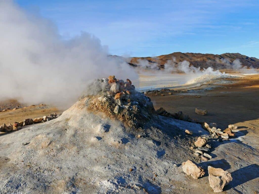 16 Nordisland Sehenswürdigkeiten, die ihr nicht verpassen dürft! dampfender-steinhaufen-im-geothermalen-gebiet-in-nordisland