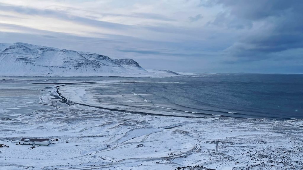 16 Nordisland Sehenswürdigkeiten, die ihr nicht verpassen dürft! winterliche-landschaft-am-meer-mit-blick-auf-verschneite-berge