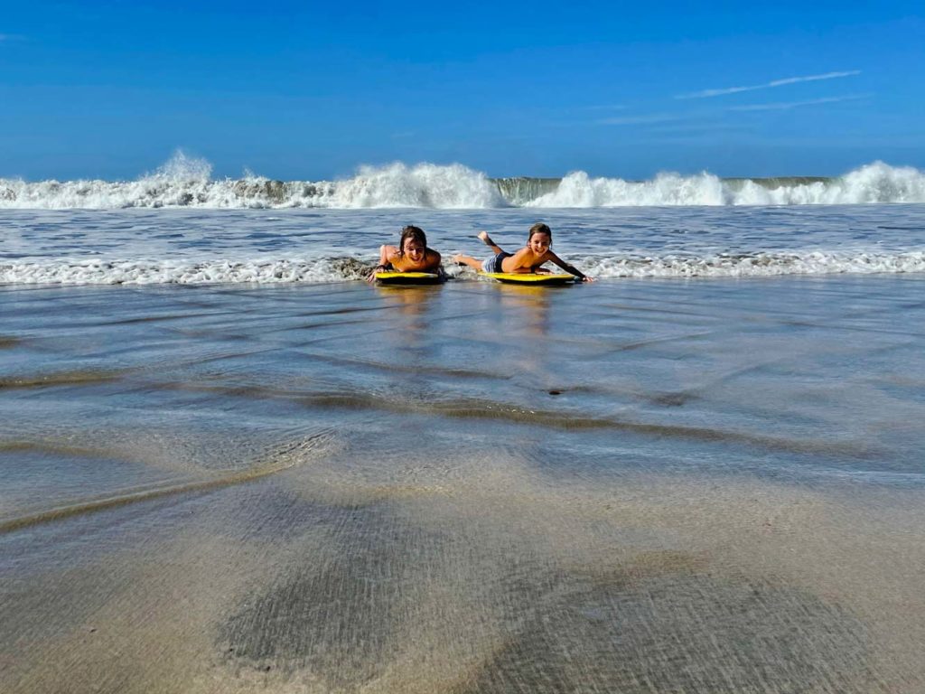 zwei-kinder-auf-boogiebords-im-meer