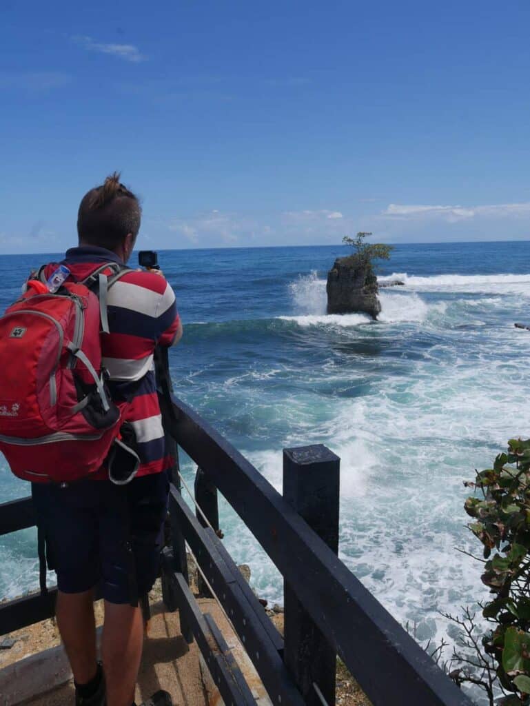 mann fotografiert landschaft am meer in costa rica