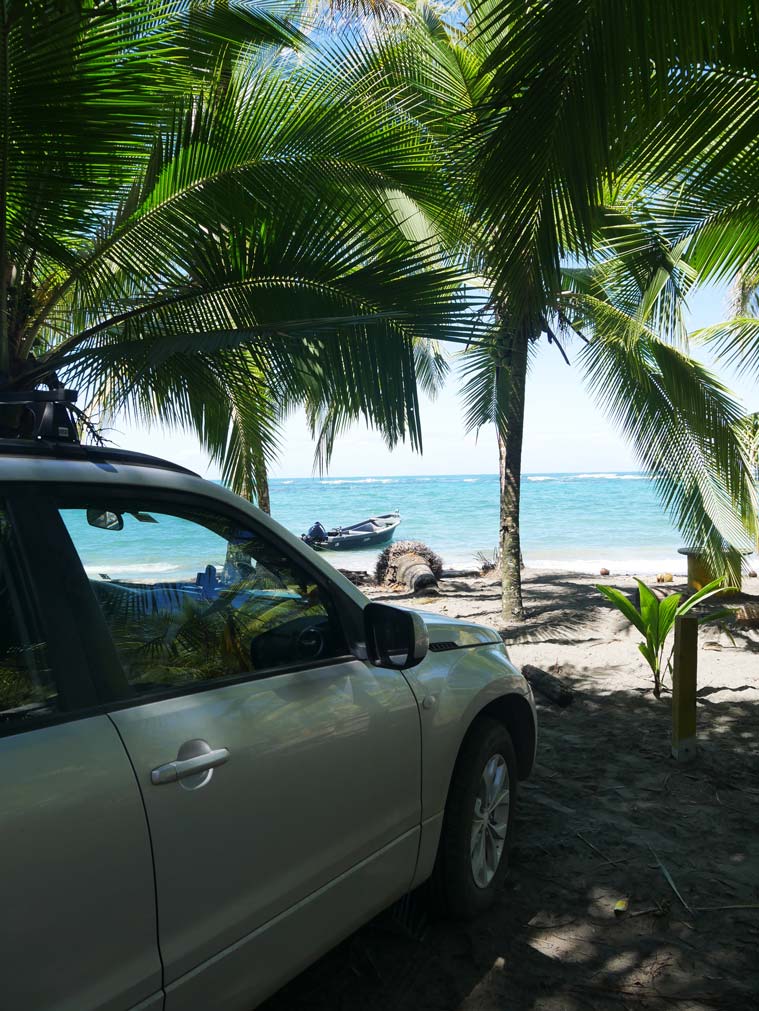 auto parkt an strand in costa rica