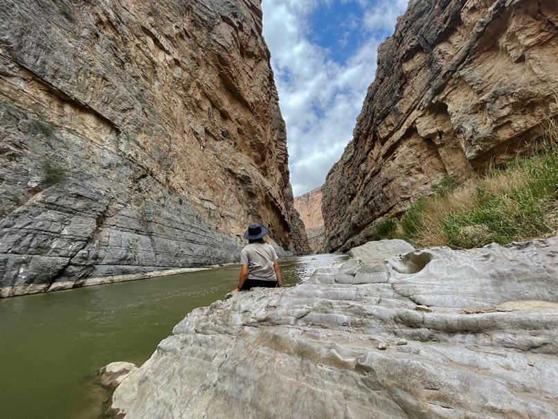 kind-sitzt-am-rio-grande-im-canyon-big-bend-nationalpark-roadtrip-quer-durch-die-usa