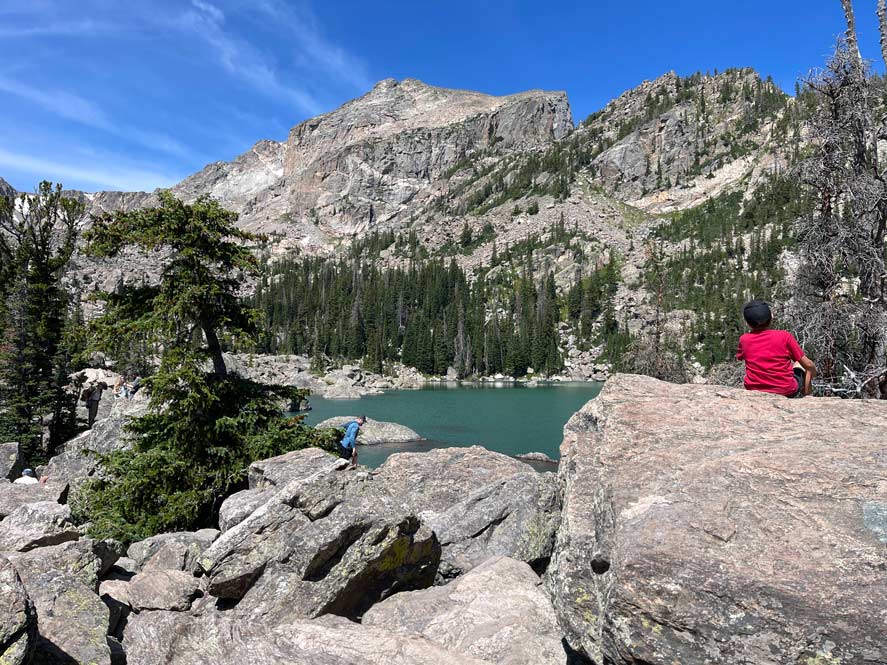 kind am see in berglandschaft in den rocky mountains