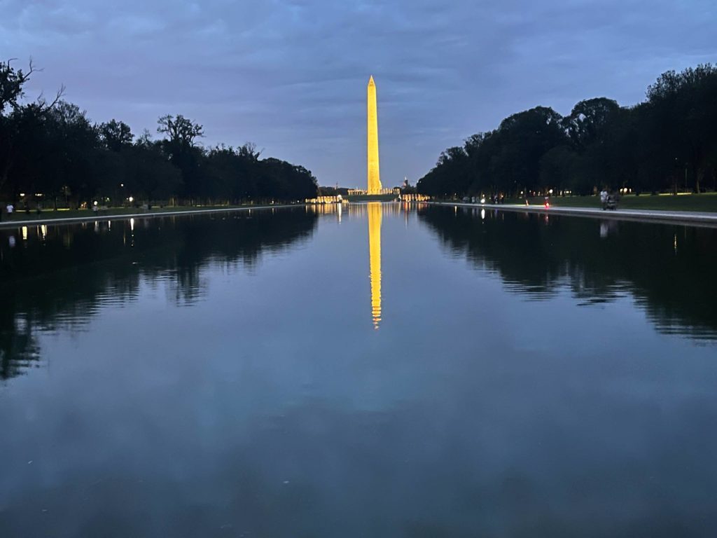 beleuchtetes-washington-monument-reflektiert-sich-im-wasserbecken-bei-dunkelheit