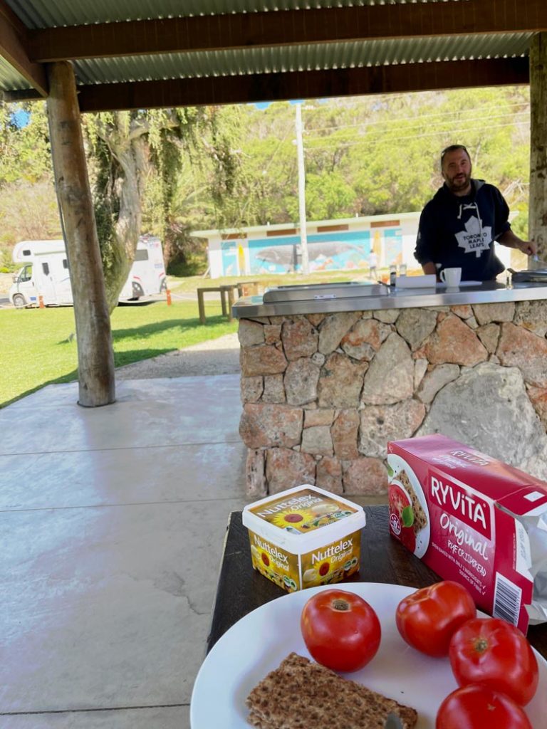 mann-grillt-am-kostenlosen-grill-in-australien-im-hintergrund-steht-das-wohnmobil