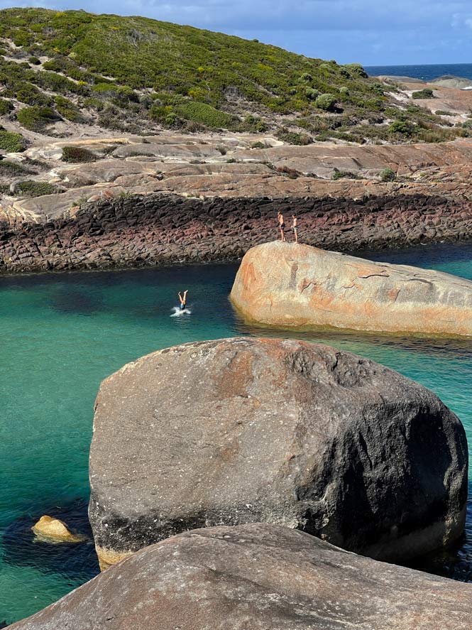 SĂĽdwesten Australiens - Highlights fĂĽr die 2-Wochen Rundreise ab Perth zwei-kinder-stehen-auf-fels-im-meer-ein-anderes-ist-gerade-ins-wasser-gesprungen-man-sieht-nur-die-fuesse-in-die-luft-stehen