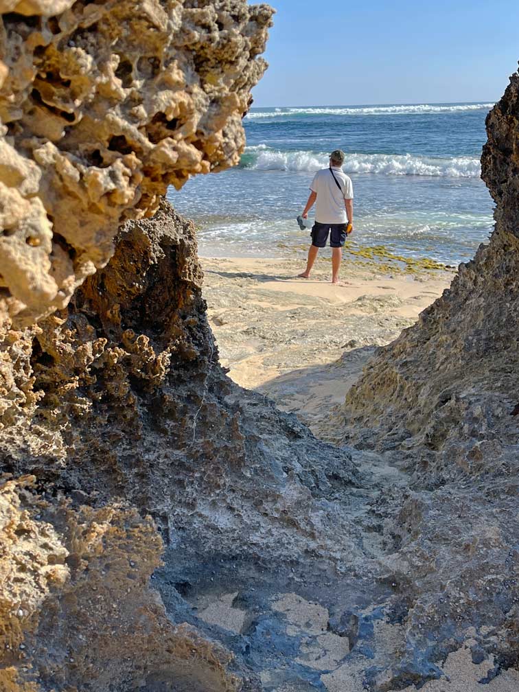 SĂĽdwesten Australiens - Highlights fĂĽr die 2-Wochen Rundreise ab Perth blick-durch-vom-wasser-ausgewaschene-felsen-auf-mann-der-am-meer-steht