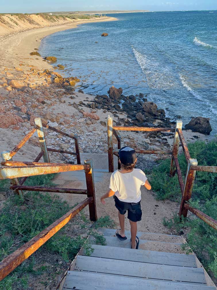 kind-laeuft-treppe-zur-strand-bucht-in-westaustralien-runter