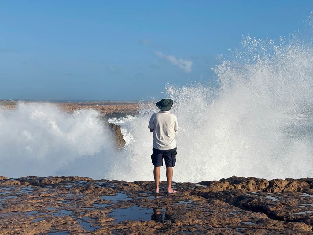 mann-steht-auf-felsen-vor-ihm-peitschen-wilde-blowholes-in-die-hoehe-point-quobba-in-western-australia