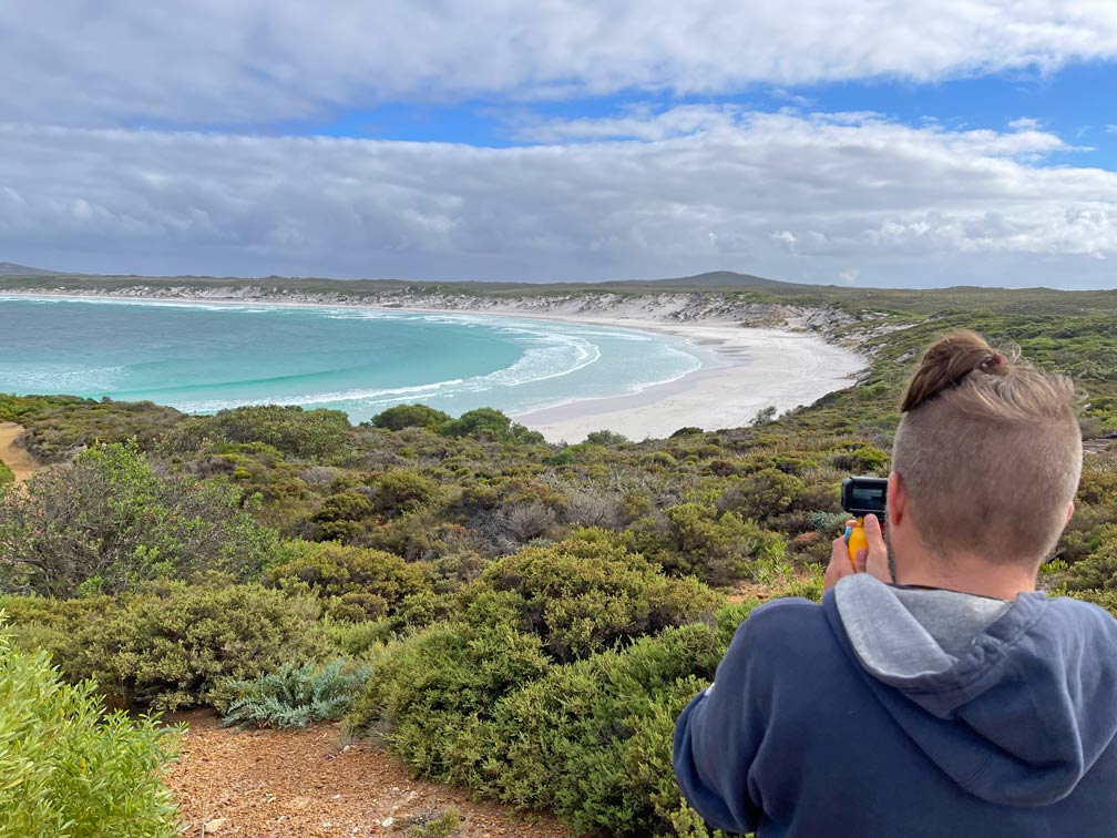 SĂĽdwesten Australiens - Highlights fĂĽr die 2-Wochen Rundreise ab Perth mann-filmt-weisse-sandstrand-bucht-die-von-gruenen-baeumen-eingerahmt-wird