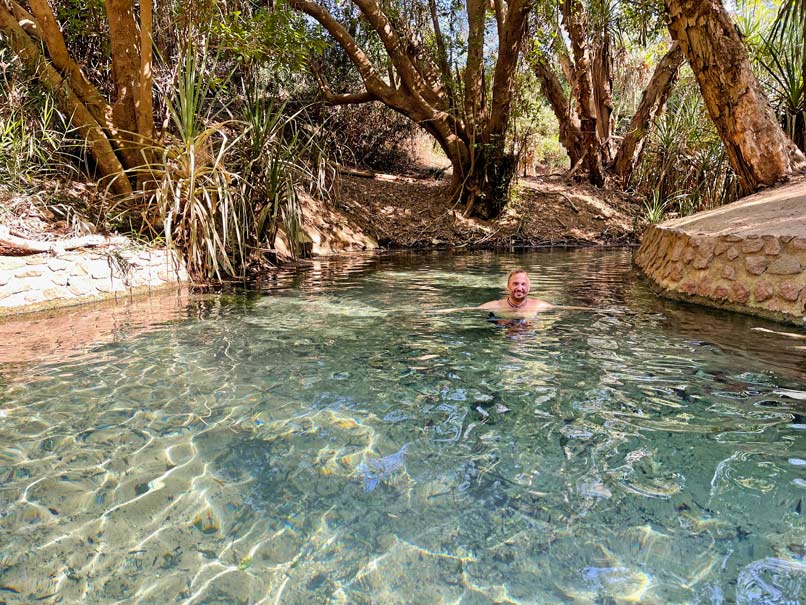 Roadtrip Northern Territory - Rundreise von Darwin zum Uluru mann-badet-in-klarer-heisser-quelle-in-den-tropen