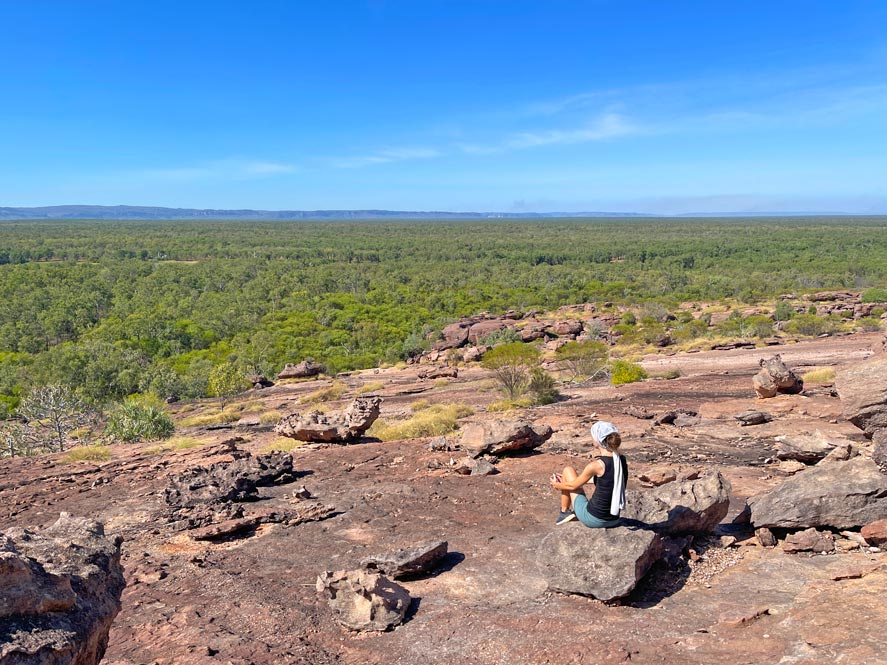 jenni von der strandfamilie sitzt auf felsen und blickt ueber die weite ebene in australien