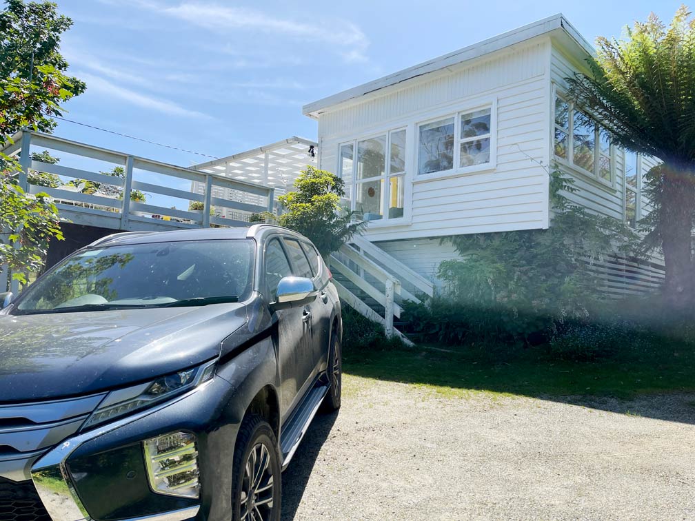 Australien: Camper oder Mietwagen? Erfahrungen und Tipps weißes-ferienhaus-mit-terrasse-in-australien-mit-mietwagen-davor