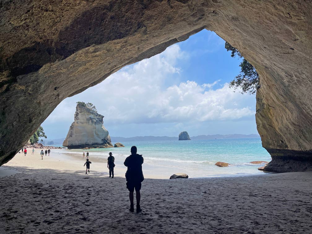 Route Nordinsel Neuseeland - 7 unvergessliche Highlights für euren Roadtrip mit Mietwagen oder Camper blick-aus-kathedralenfoermiger-hoehle-die-zwei-straende-verbindet-auf-das-meer-und-felsformation-cathedral-cove-neuseeland-nordinsel-highlights