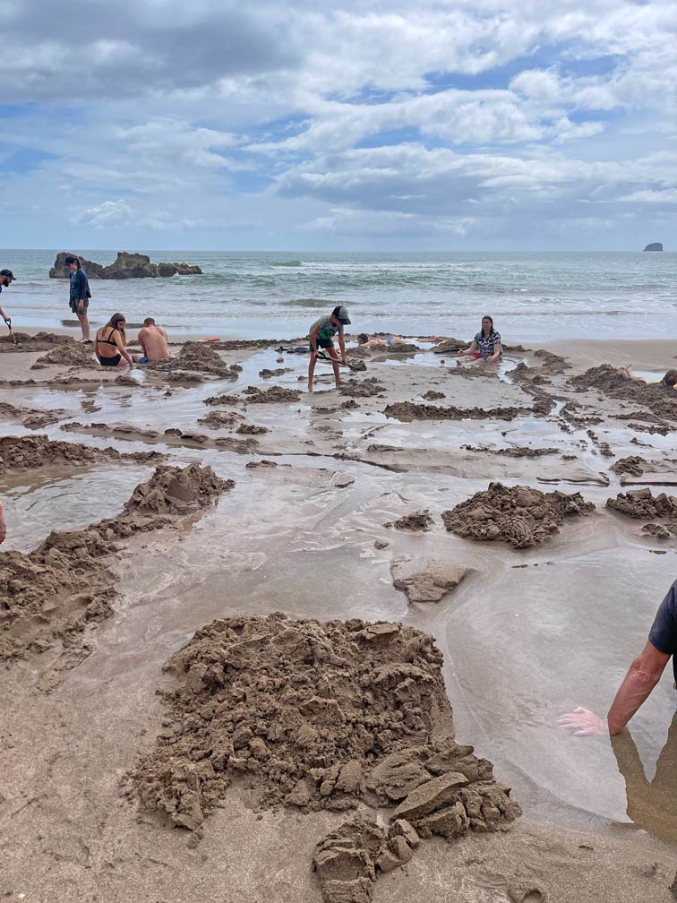 kind-graebt-loch-am-hot-water-beach-neuseeland