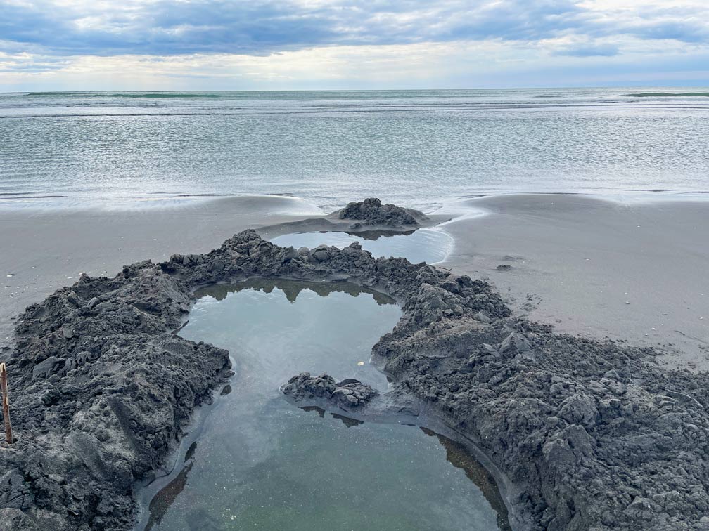 selbstgebuddelter-sandpool-am-schwarzen-strand-kawhia-hot-water-beach-neuseeland-nordinsel