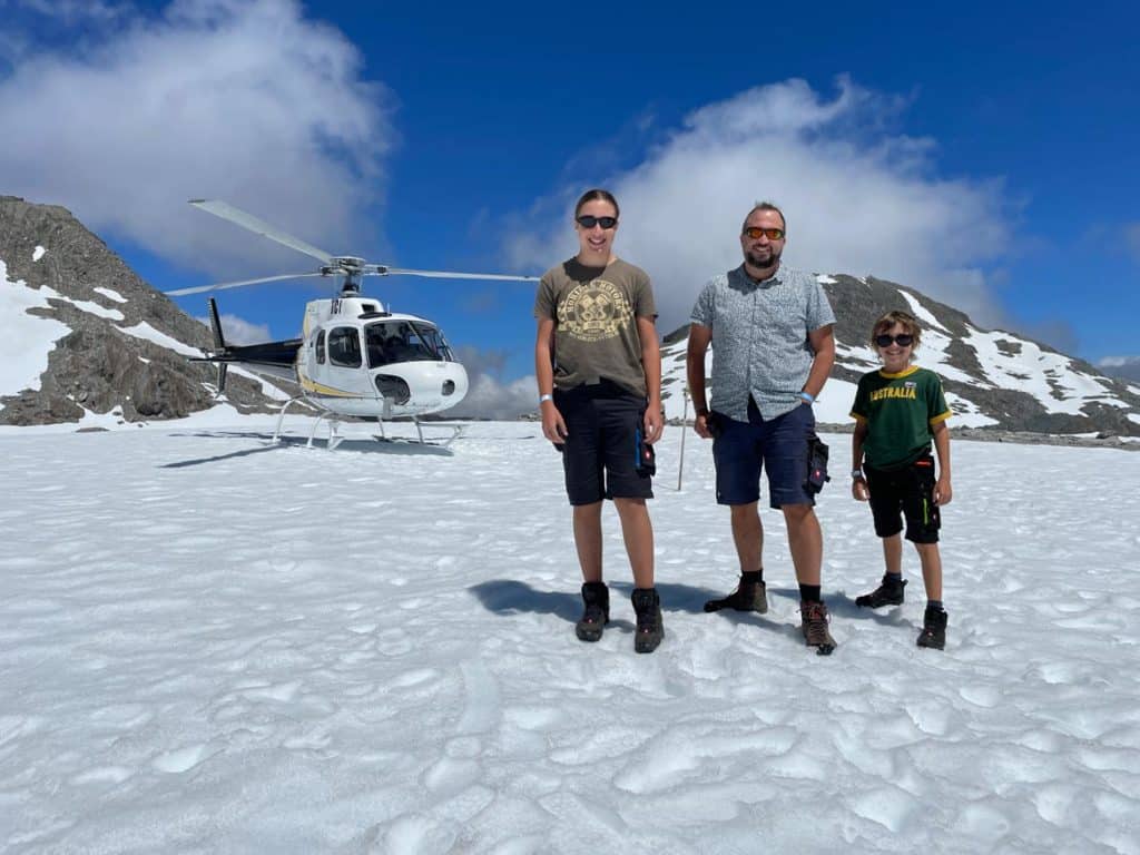 familie-steht-vor-helikopter-auf-dem-franz-josef-gletscher-auf-der-suedinsel-neuseeland