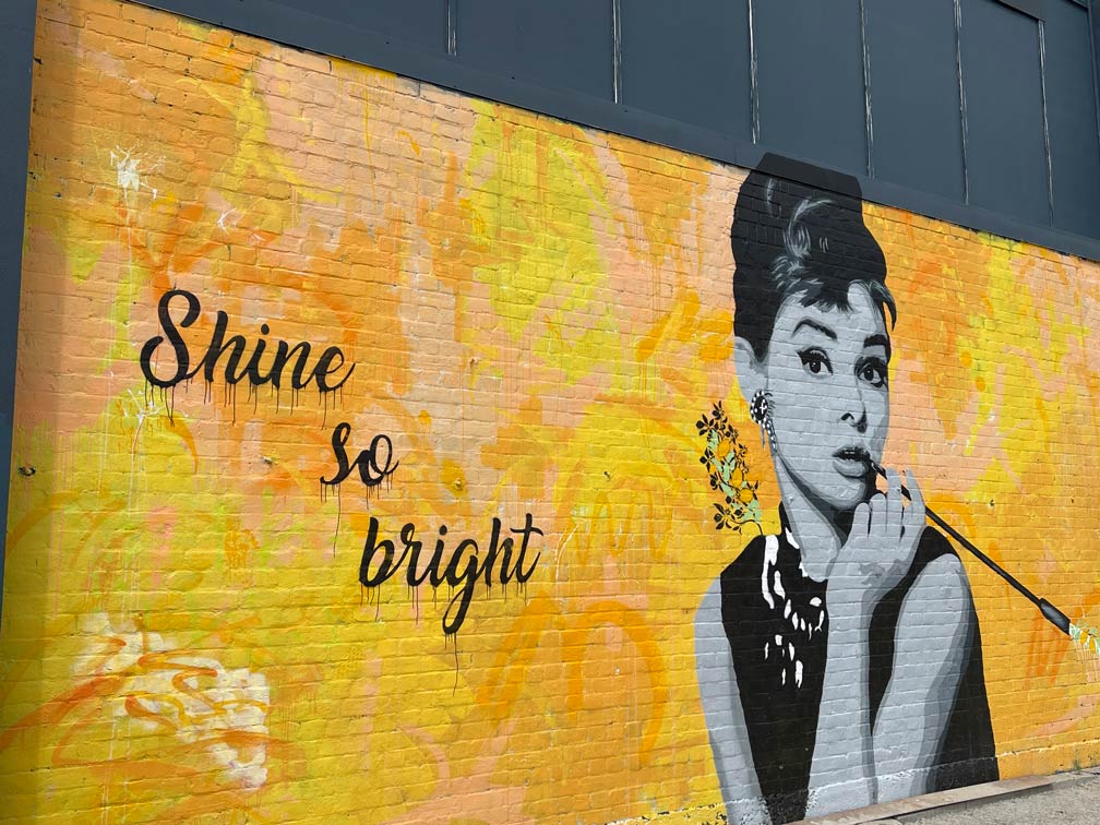 streetart-gelber-untergrund-mit-frau-und-spruch-shine-so-bright-in-christchurch