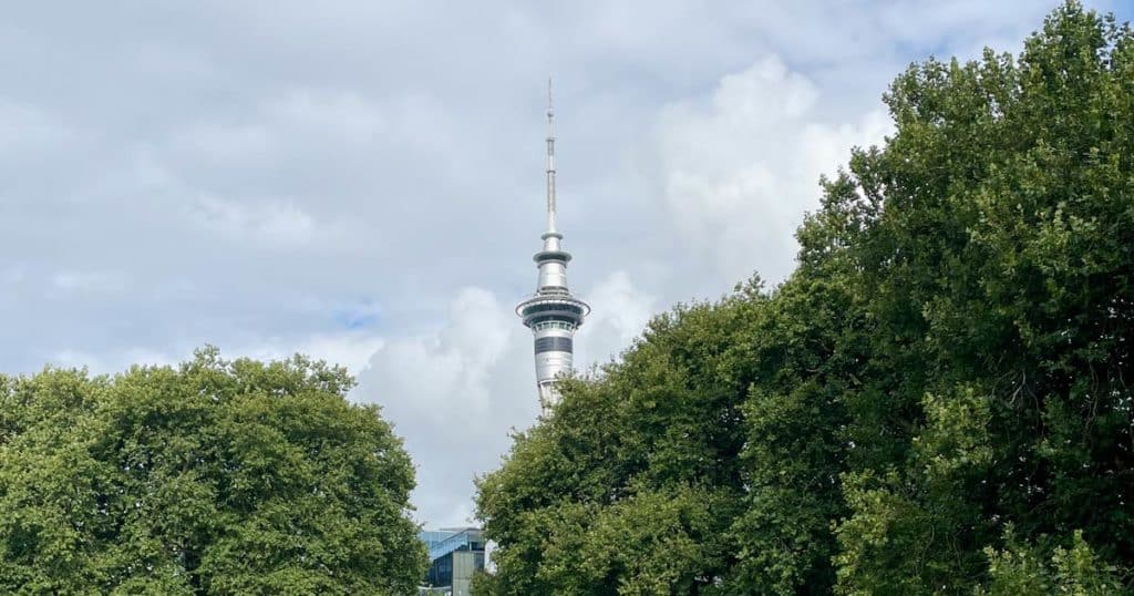 skytower auckland ragt zwischen grünen bäumen hervor