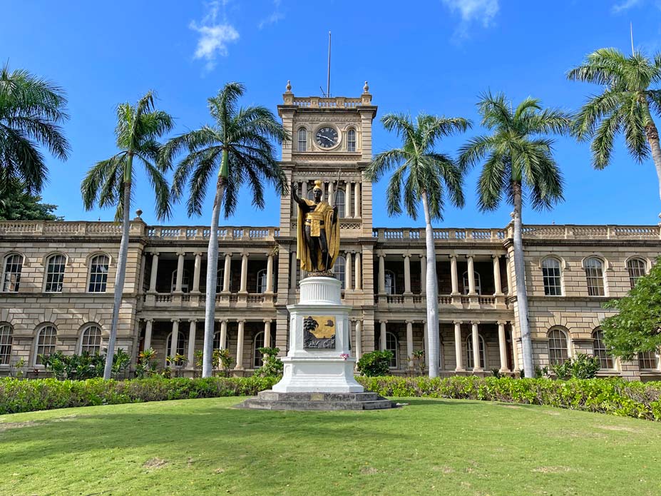 statue-vor-praechtigem-gebauede-mit-palmen-in-honolulu