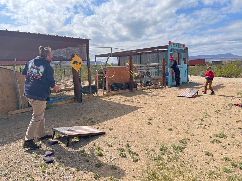 familie-spielt-corn-whole-vor-stall-in-der-wueste-texas-campingplatz-usa-privater-campground