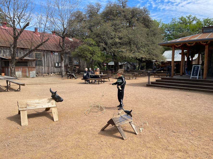 kind-wirft-lasso-auf-holztier-in-luckenbach-texas