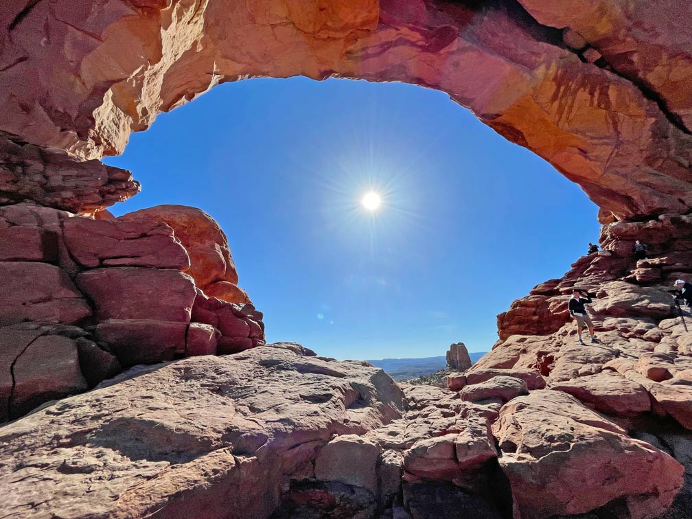 blick-durch-roten-felsbogen-in-die-sonne-im-arches-nationalpark