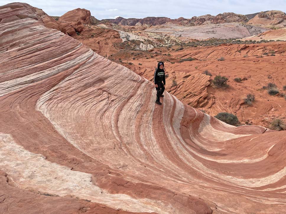 kind-auf-felsen-mit-weiss-roten-streifen-im-valley-of-fire-state-park