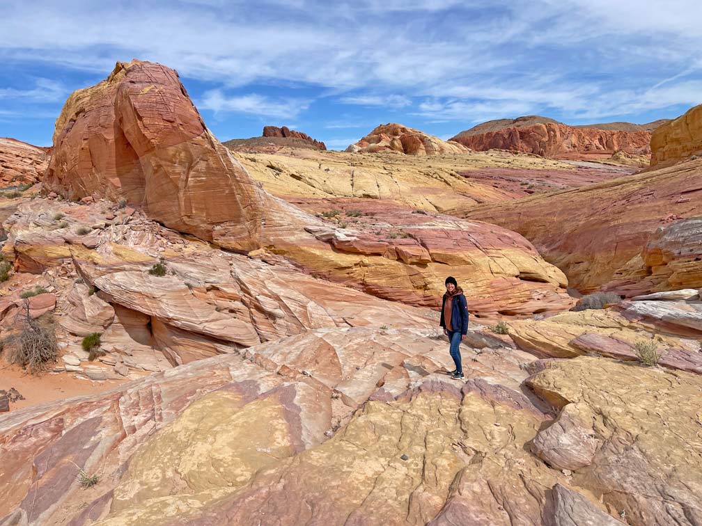 Las Vegas Ausflüge - 4 Highlights in der Umgebung frau-steht-in-rot-gelb-farbener-stein-landschaft-im-valley-of-fire-bei-las-vegas