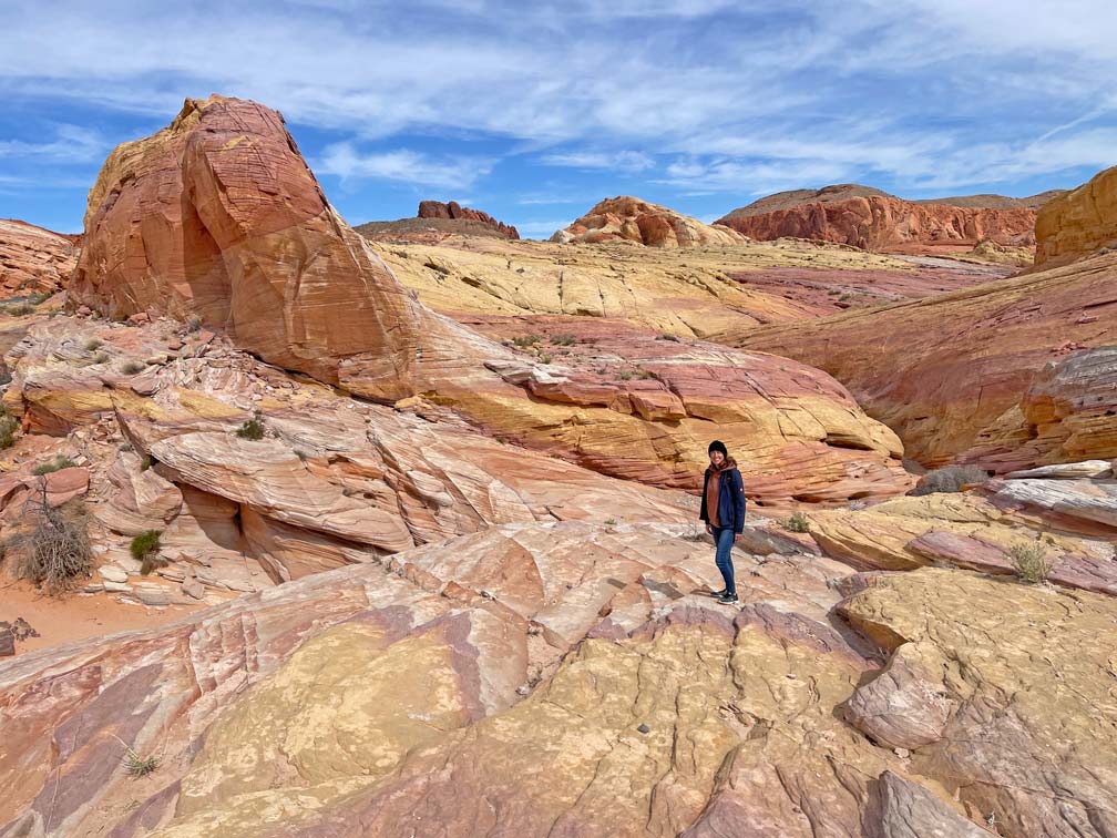 frau-steht-in-rot-gelb-farbener-stein-landschaft-im-valley-of-fire-bei-las-vegas