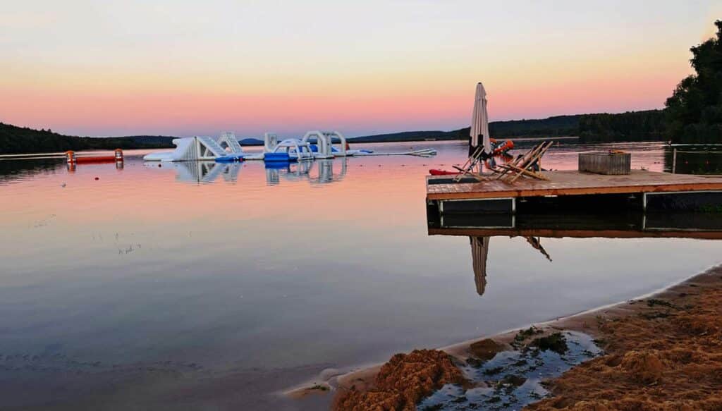 sonnenuntergang-am-strand-am-bromnbachsee-mit-blick-auf-leeren-steeg-und-kinderhuepfburg