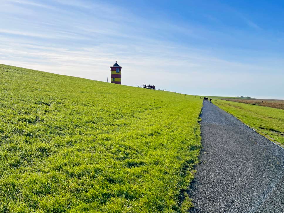 rot-gelb-gestreifter-leuchtturm-am-deich-otto-leuchtturm-pilsum-sehenswuerdigkeiten-ostfriesland-mit-kindern