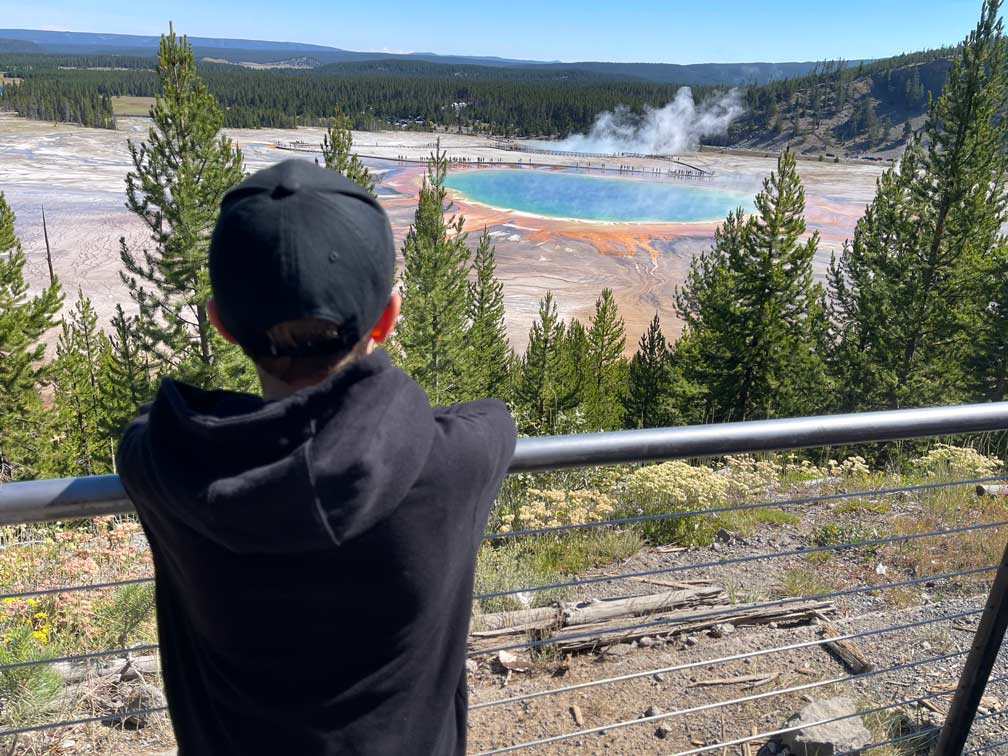 kind steht am aussichtspunkt auf grand prismatic spring im yellowstone