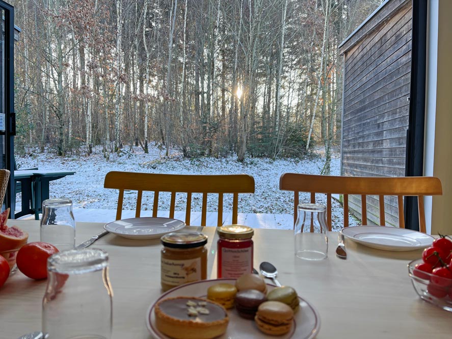 Center Parcs Les Trois Forets - Familienurlaub im Elsass gedeckter-fruehstueckstisch-mit-gebaeck-im-centerparc-elsass-mit-blick-auf-die-offene-mit-schneebedeckte-terrasse-am-waldrand