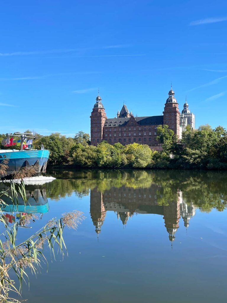 schiff fährt über den main vorbei am schloss in aschaffenburg