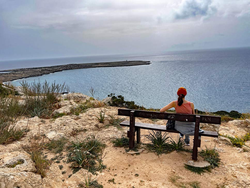 frau-sitzt-auf-bank-mit-blick-aufs-mittelmeer