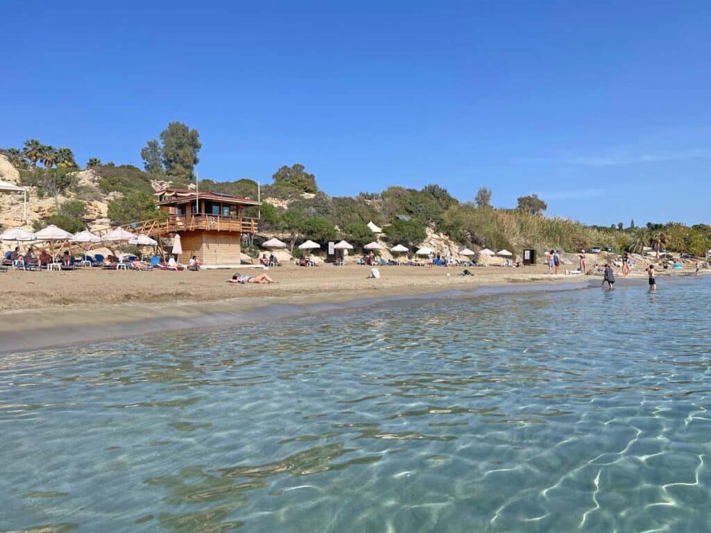 schimmerndes-klares-meerwasser-am-sandstrand-mit-liegestuehlen