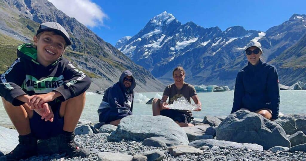 strandfamilie-sitzt-am-gletschersee-in-neuseeland