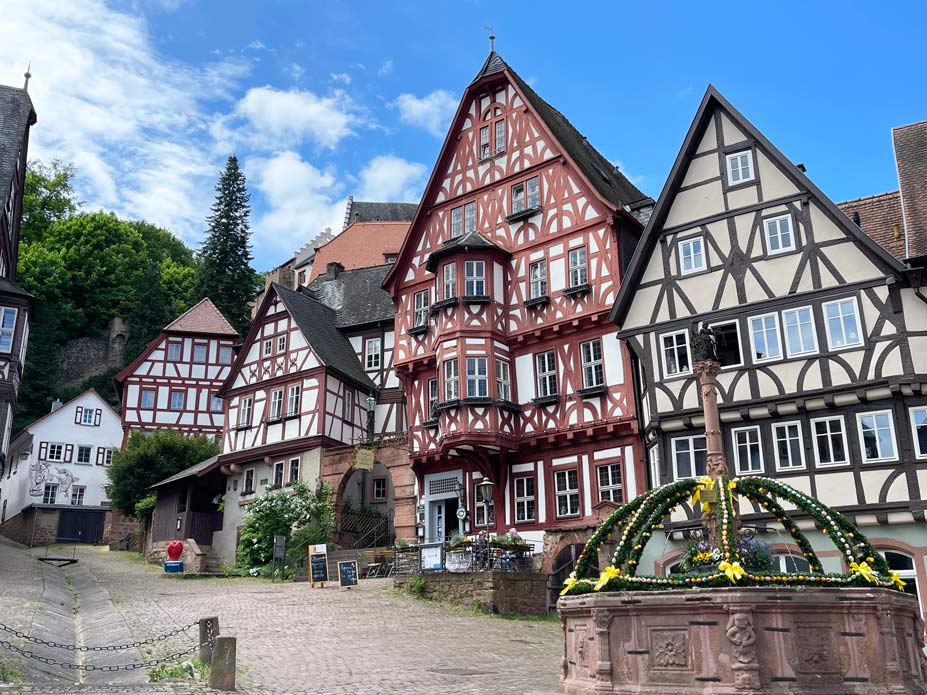 Sehenswürdigkeiten in Miltenberg - charmante Fachwerkhäuser am Main sandsteinbrunnen als osterbrunnen vor fachwerkhäusern in miltenberg